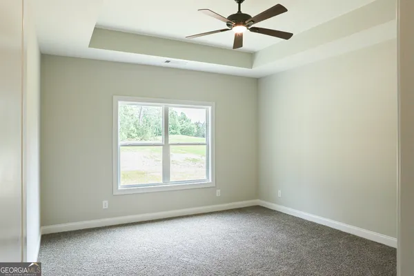 an empty room with a window and a fan