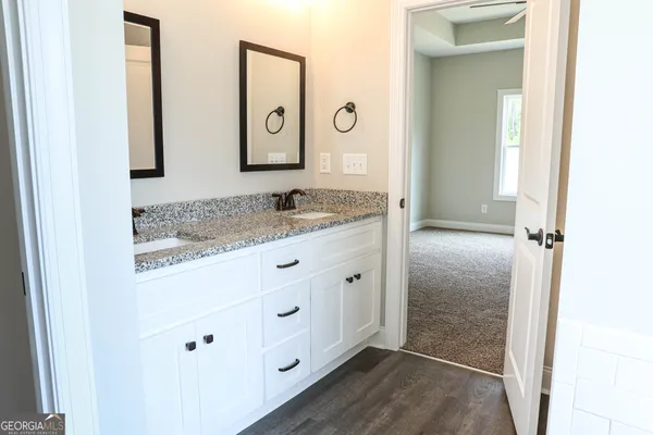 a bathroom with a granite countertop sink and a mirror