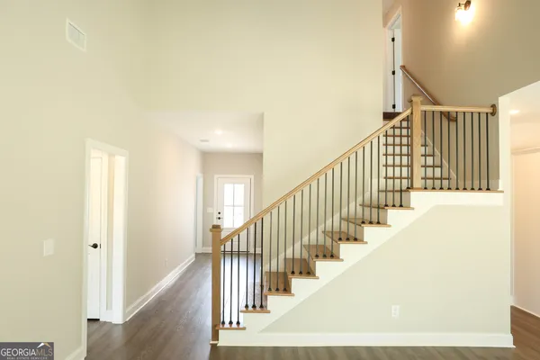 a view of staircase with lots of frames on wall and a large window