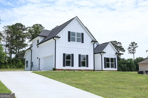 a front view of a house with a garden