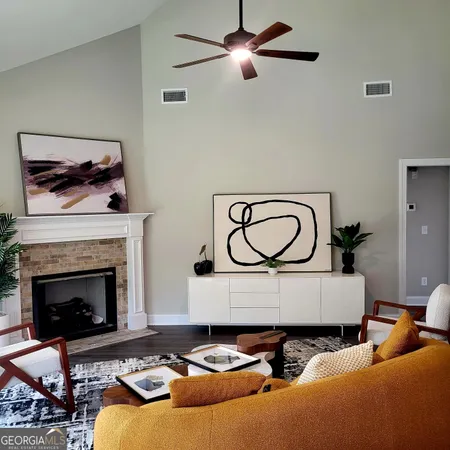 a living room with furniture a fireplace and a wall painting