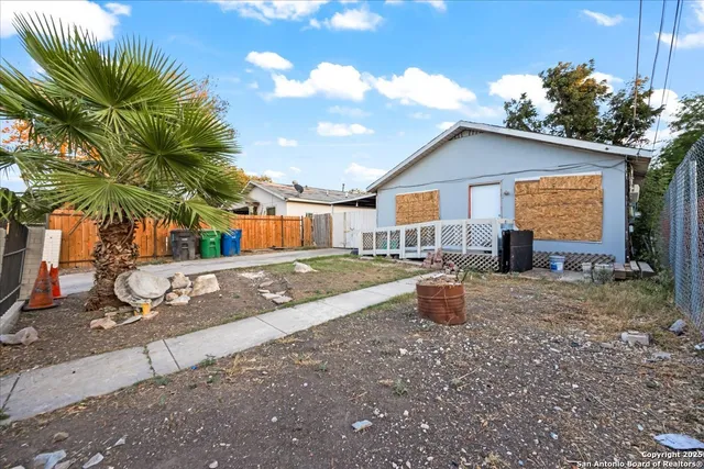 a backyard of a house with barbeque oven table and chairs