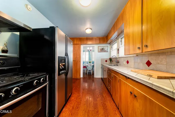 a large kitchen with stainless steel appliances granite countertop a sink and a refrigerator