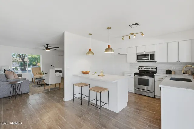 a kitchen with a sink a stove and wooden floor