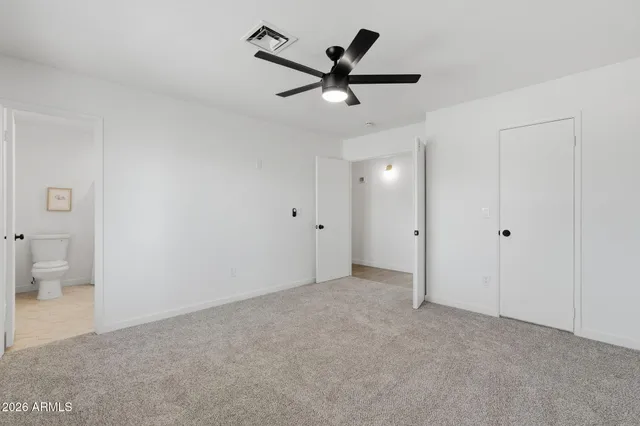 a view of an empty room and a ceiling fan
