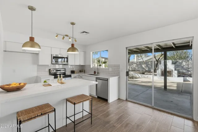 a kitchen with sink a stove and chairs