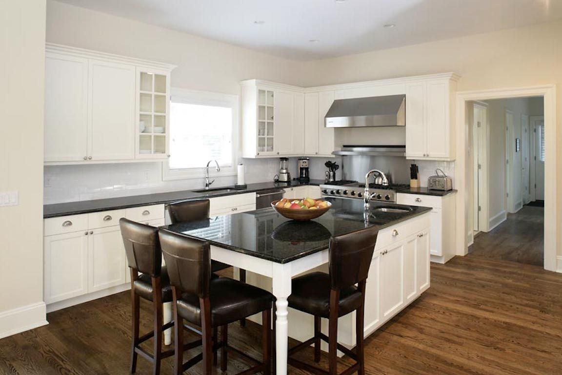 Undisclosed Address Quogue, NY 11959 - Photo 4 of 19 a kitchen with a dining table chairs sink and cabinets