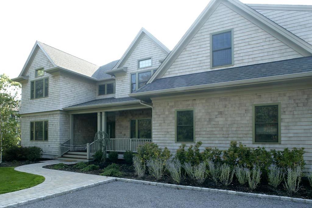Undisclosed Address Quogue, NY 11959 - Photo 9 of 19 a front view of a house with a yard and potted plants
