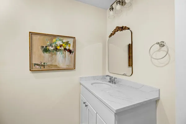 a bathroom with a granite countertop sink and a mirror