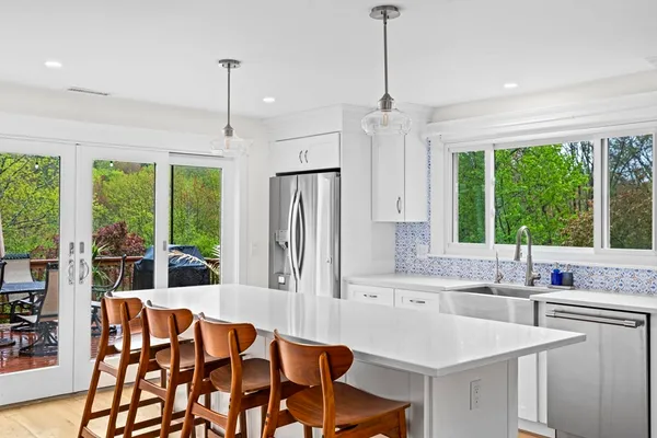 a kitchen with a stove a sink and a dining table chair