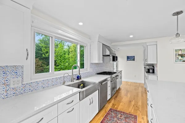 a kitchen with stainless steel appliances a sink a stove and a window