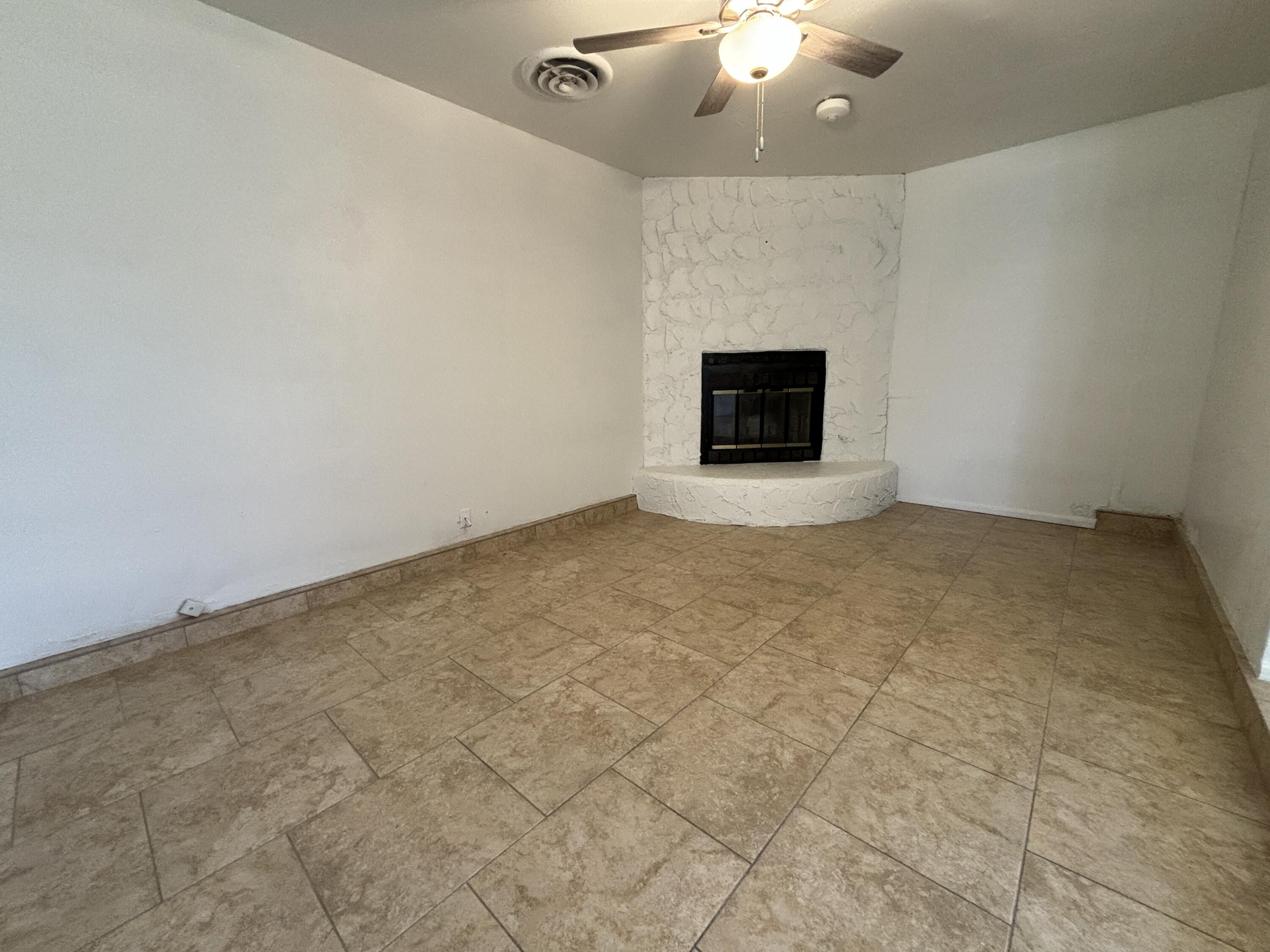 1303 46th Street Lubbock, TX 79412 - Photo 5 of 13 an empty room with a fireplace