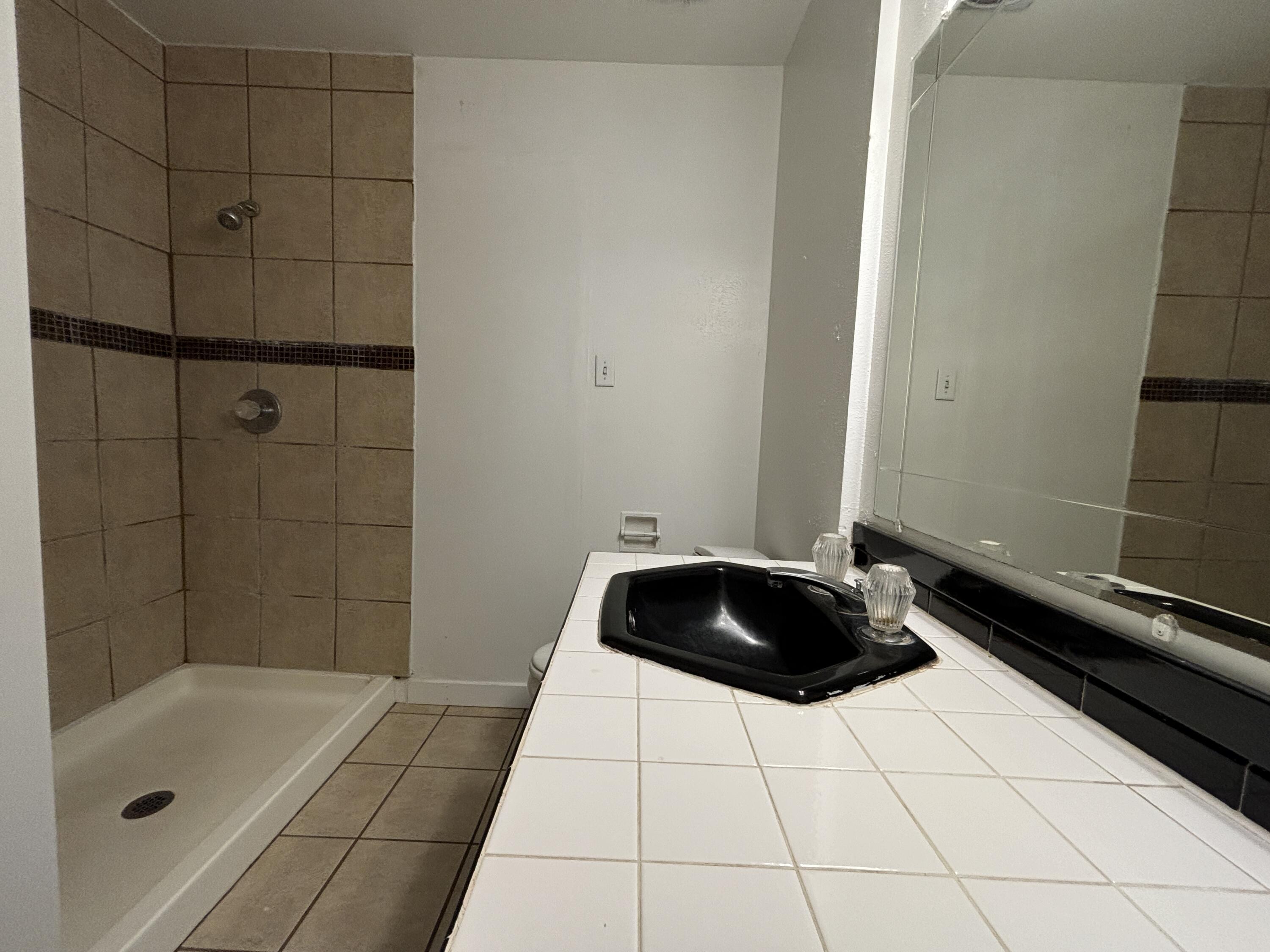 1303 46th Street Lubbock, TX 79412 - Photo 8 of 13 a bathroom with a sink and a shower