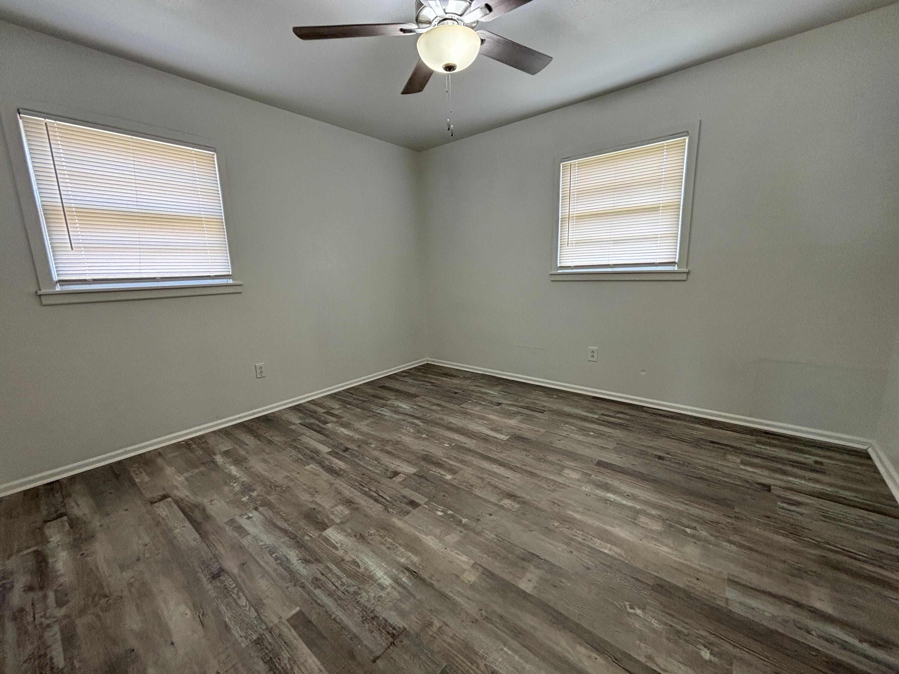 1303 46th Street Lubbock, TX 79412 - Photo 9 of 13 a view of an empty room with wooden floor and a window