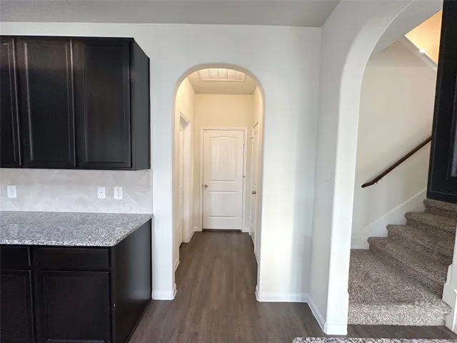 an entryway with wooden floor and cabinet
