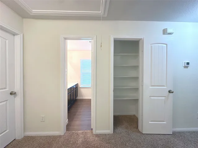 a view of an empty room with closet and a window