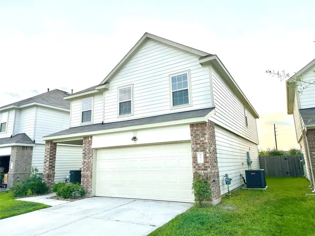 a view of a house with a yard and a garage