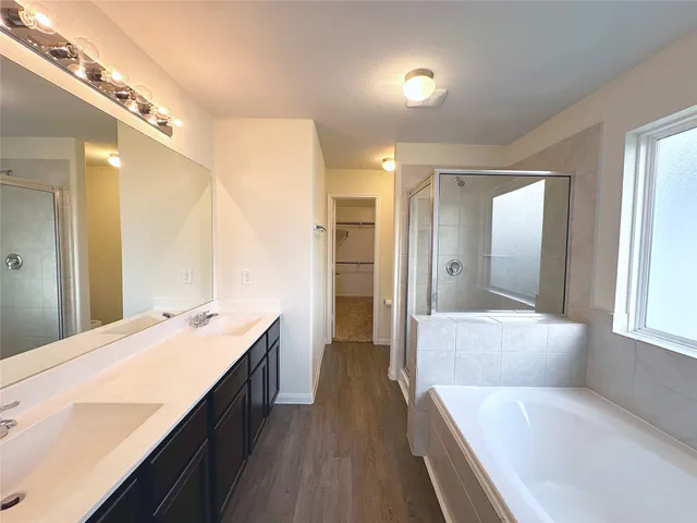 a large bathroom with a large mirror vanity and shower