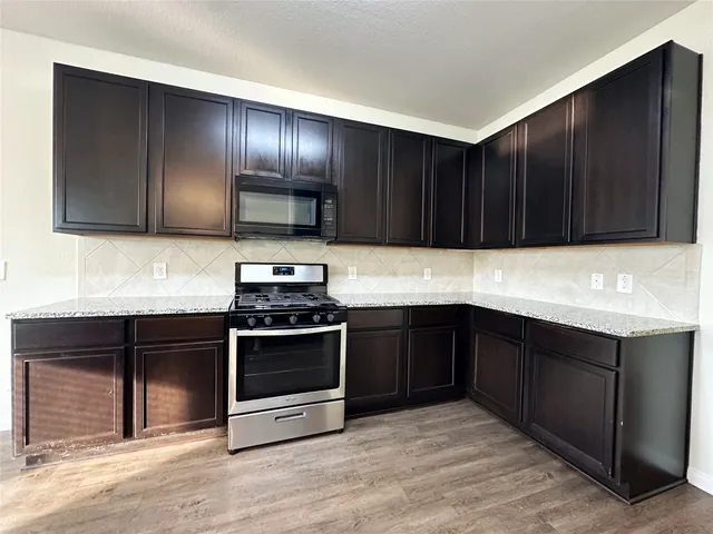 a kitchen with granite countertop wooden cabinets and stainless steel appliances