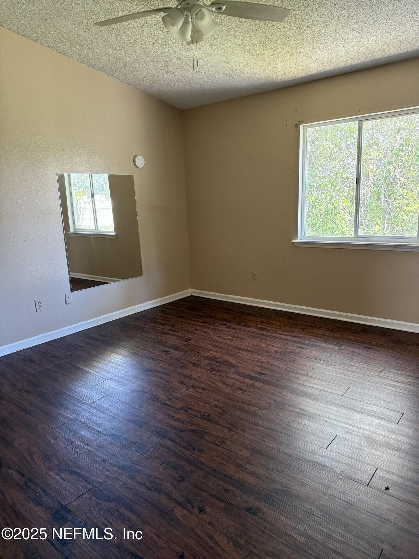 791 Assisi Lane, Unit 803 Jacksonville, FL 32233 - Photo 13 of 15 an empty room with wooden floor and windows