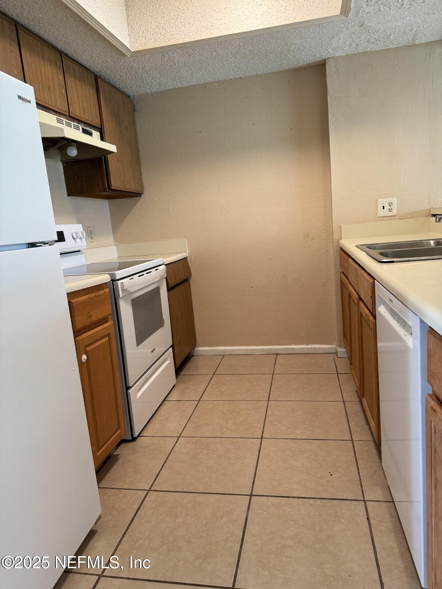 791 Assisi Lane, Unit 803 Jacksonville, FL 32233 - Photo 2 of 15 a kitchen with a sink a stove top oven a sink and a counter top space