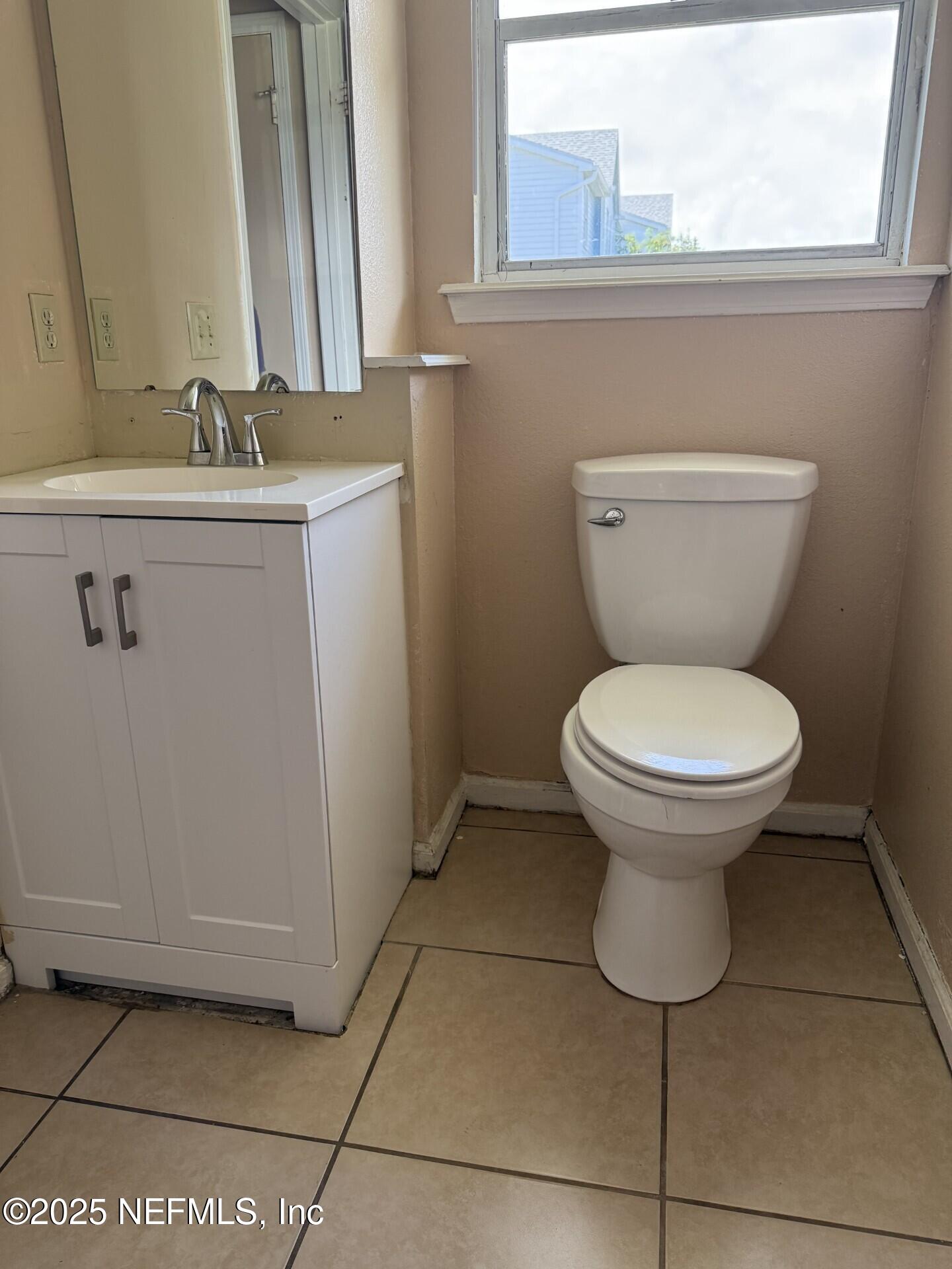 791 Assisi Lane, Unit 803 Jacksonville, FL 32233 - Photo 5 of 15 a bathroom with a toilet sink and mirror