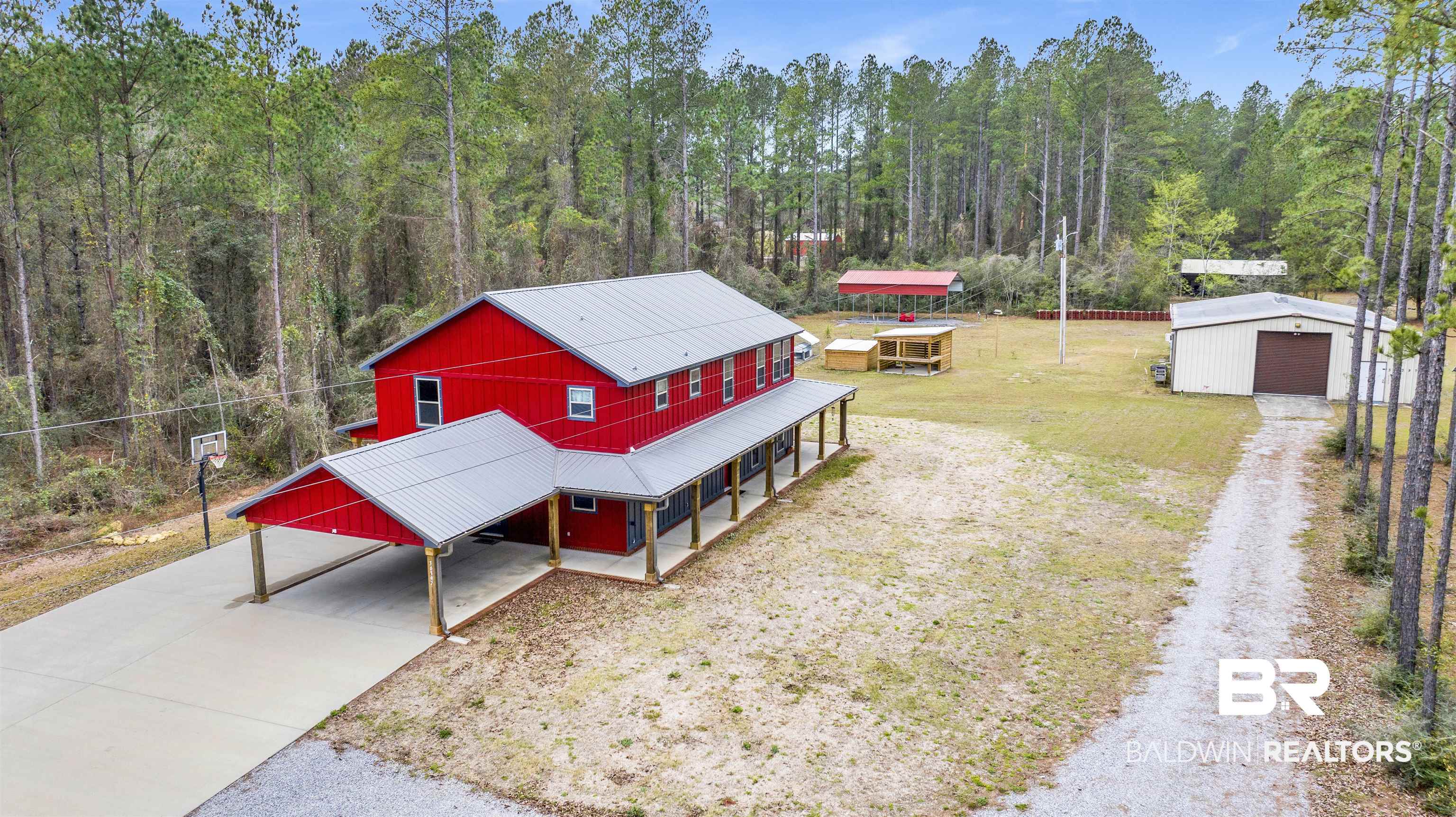 36397 Alexandria Trail Stapleton, AL 36578 - Photo 3 of 65 View of front facade featuring an outdoor structure, concrete driveway, a metal roof, covered porch, and a garage
