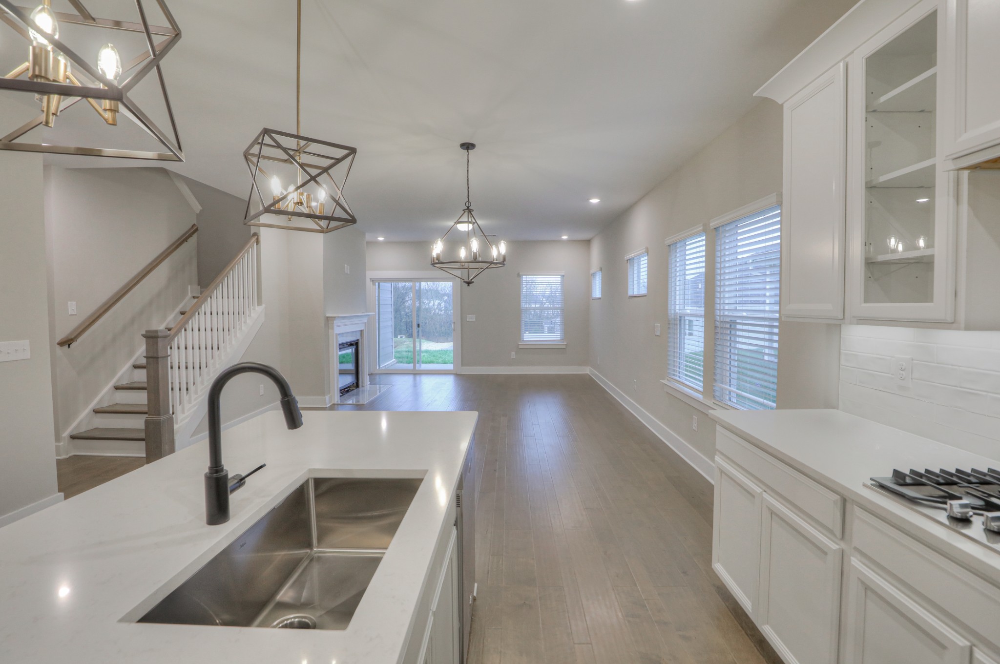 724 Castle Road Mount Juliet, TN 37122 - Photo 14 of 52 a kitchen with granite countertop a stove a sink a dining table and chairs with wooden floor
