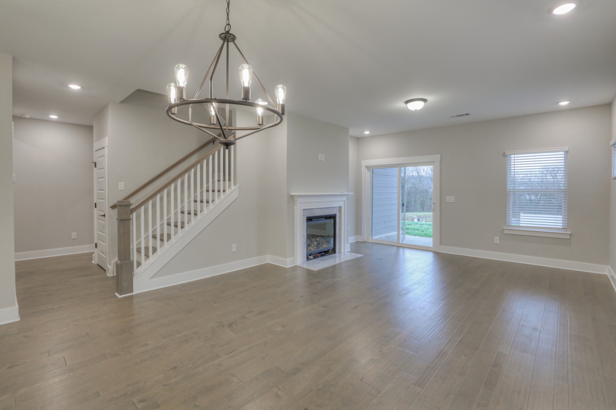 724 Castle Road Mount Juliet, TN 37122 - Photo 18 of 52 a view of a livingroom with wooden floor a ceiling fan and windows