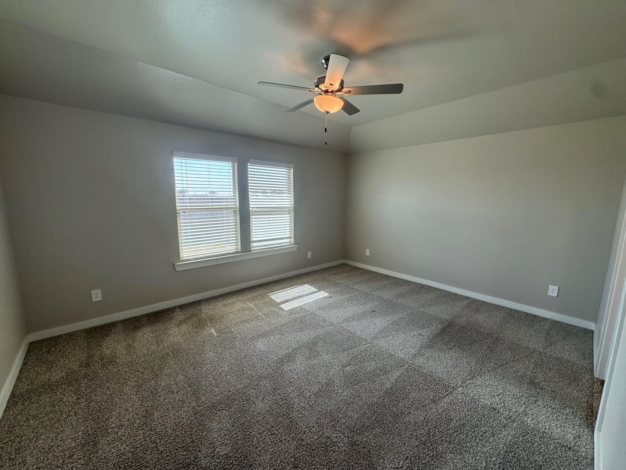 4701 126th Street Lubbock, TX 79424 - Photo 11 of 13 en empty room with windows and chandelier fan
