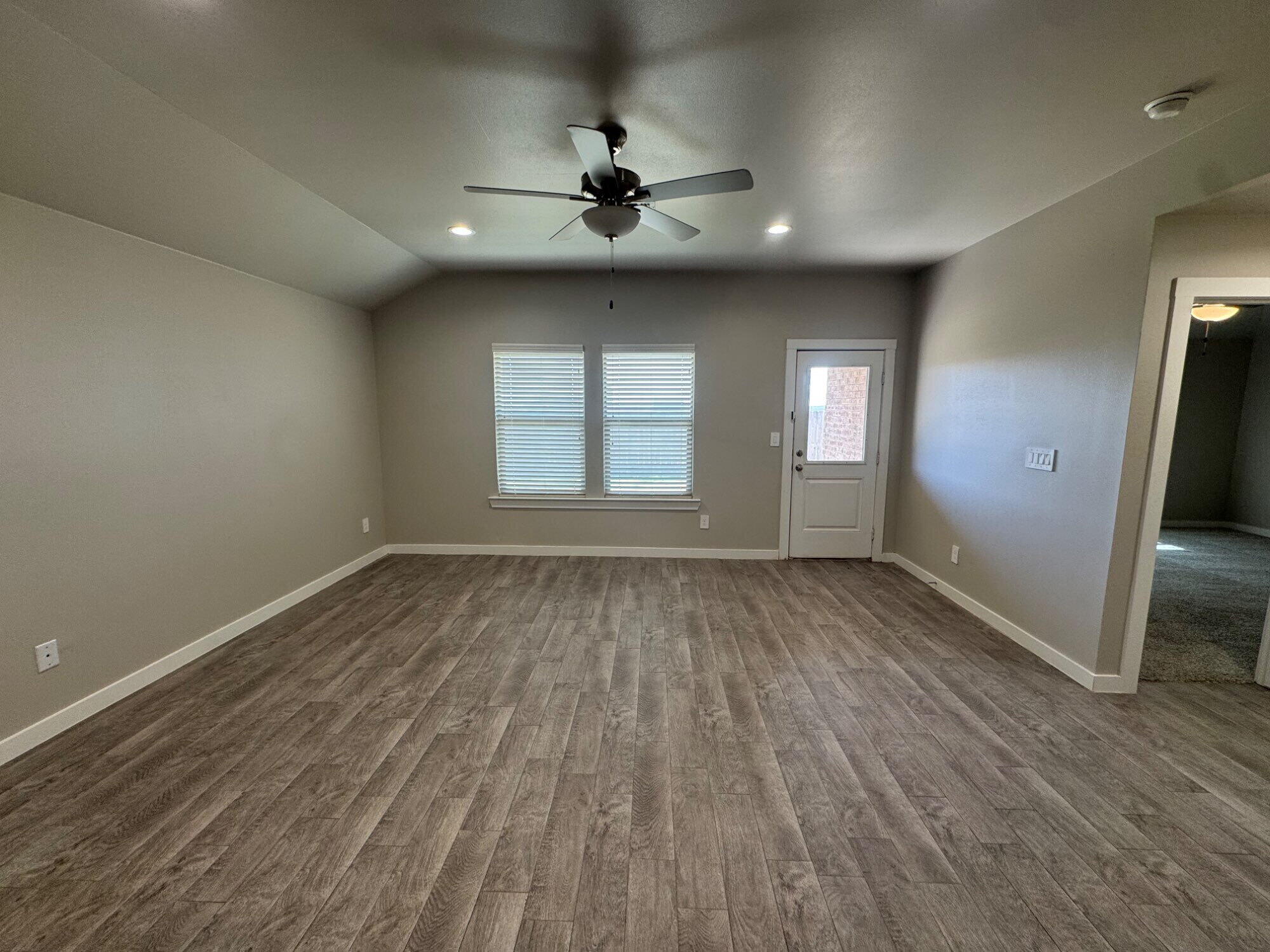4701 126th Street Lubbock, TX 79424 - Photo 8 of 13 an empty room with wooden floor and windows