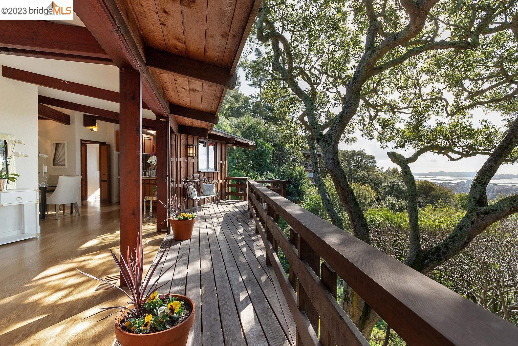 a view of a patio with couches and table with wooden floor and fence