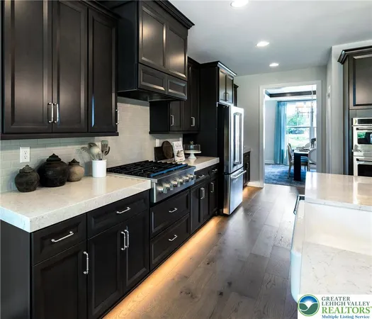 a kitchen with stainless steel appliances granite countertop a sink a stove and a refrigerator