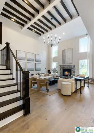 a living room with couches and kitchen view with wooden floor