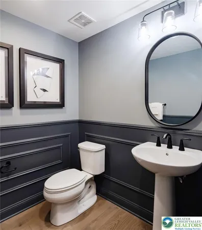 a kitchen with kitchen island stainless steel appliances a dining table chairs sink and wooden floor