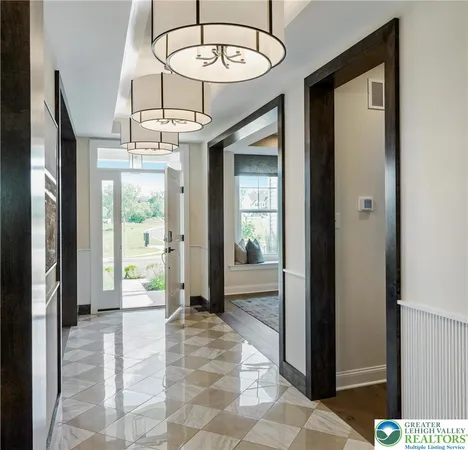a view of a hallway with a dining table and chandelier