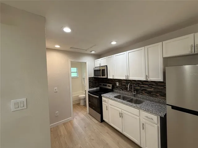 a kitchen with stainless steel appliances granite countertop a refrigerator and a sink