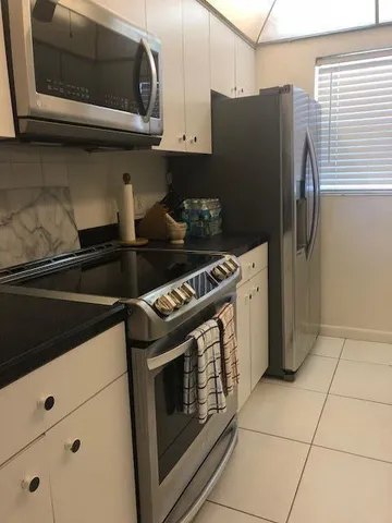 a kitchen with granite countertop a stove and a microwave