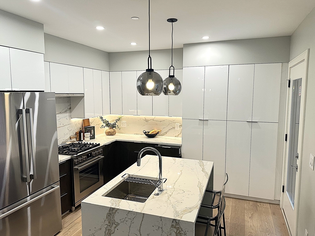 14 North Bennet Street, Unit 1 Boston, MA 02113 - Photo 4 of 20 a kitchen with a table chairs refrigerator and microwave