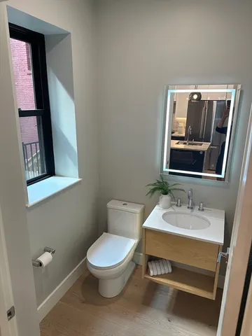 a bathroom with a toilet a sink and mirror