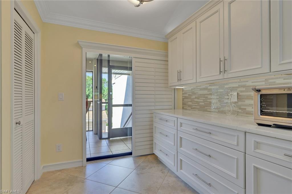 406 Foxtail Court, Unit 406 Naples, FL 34104 - Photo 13 of 42 a kitchen with granite countertop white cabinets and oven