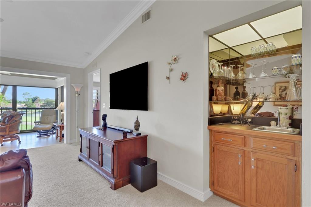 406 Foxtail Court, Unit 406 Naples, FL 34104 - Photo 15 of 42 a living room with furniture and a flat screen tv