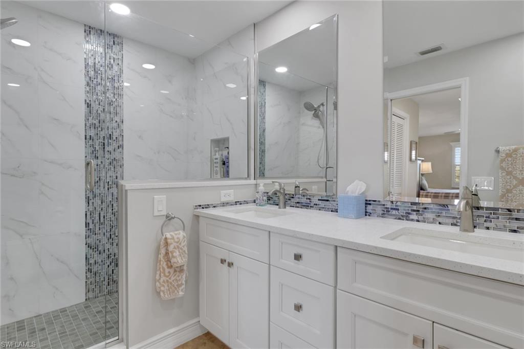 406 Foxtail Court, Unit 406 Naples, FL 34104 - Photo 5 of 42 a bathroom with double vanity and a mirror