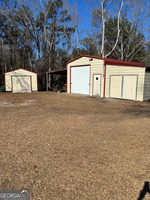 592 Clifford Meeks Road Collins, GA 30421 - Photo 26 of 52 a view of a house with a yard and garage