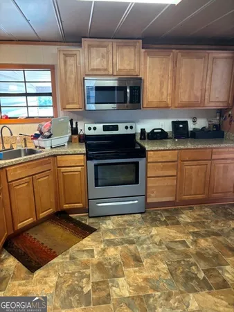 a kitchen with stainless steel appliances a stove a sink a microwave and cabinets