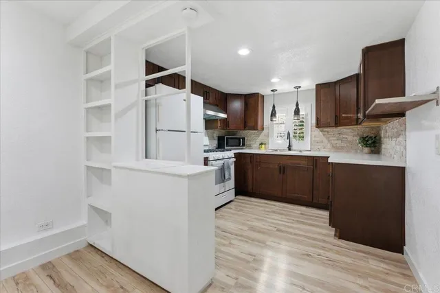 a kitchen with kitchen island wooden cabinets and refrigerator