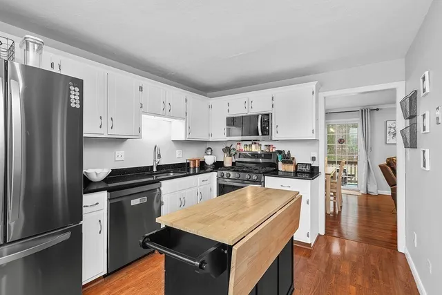 a kitchen with stainless steel appliances granite countertop a refrigerator stove microwave and sink