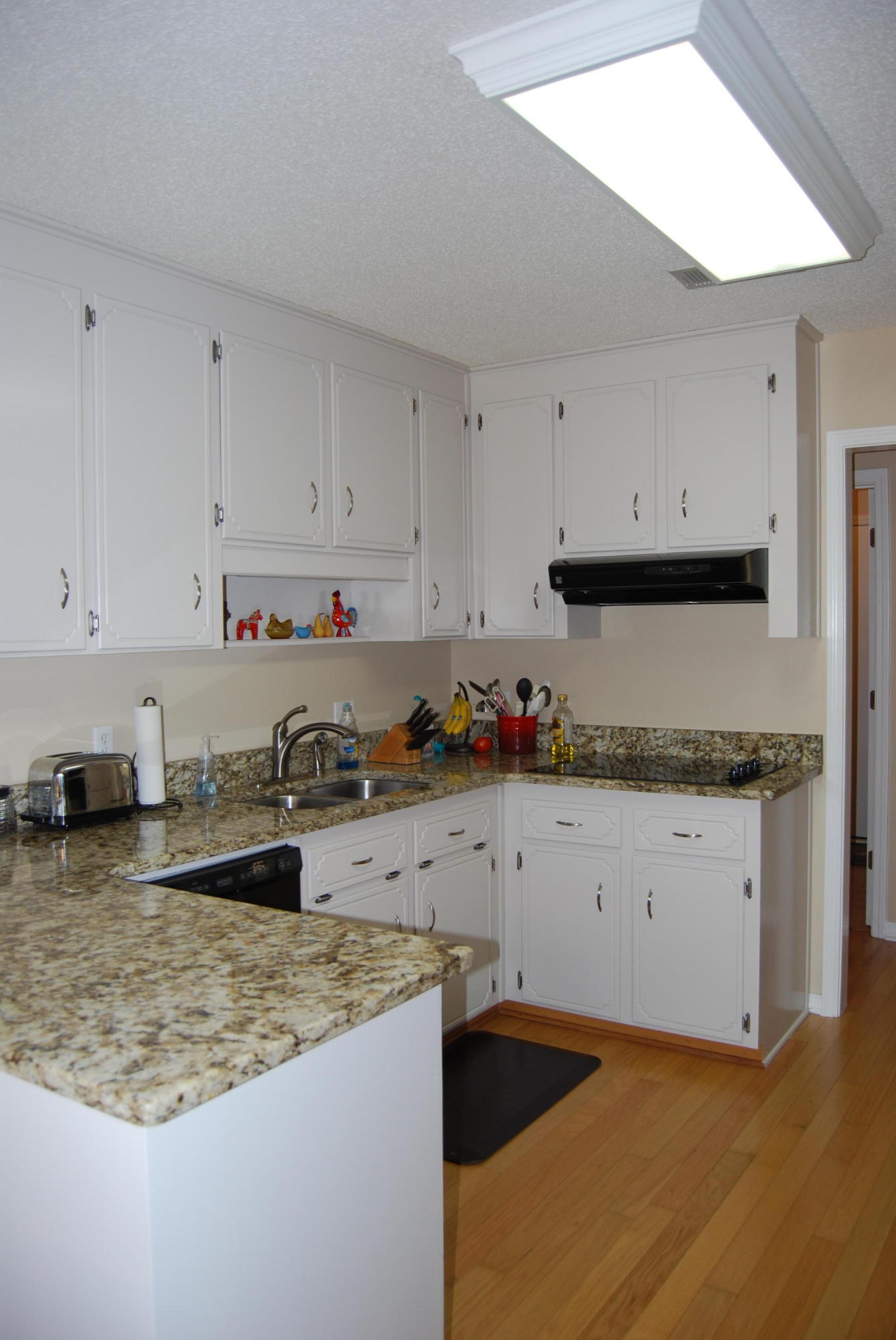 4455 Kingslynn Road Niceville, FL 32578 - Photo 12 of 36 a kitchen with granite countertop a sink stove and white cabinets