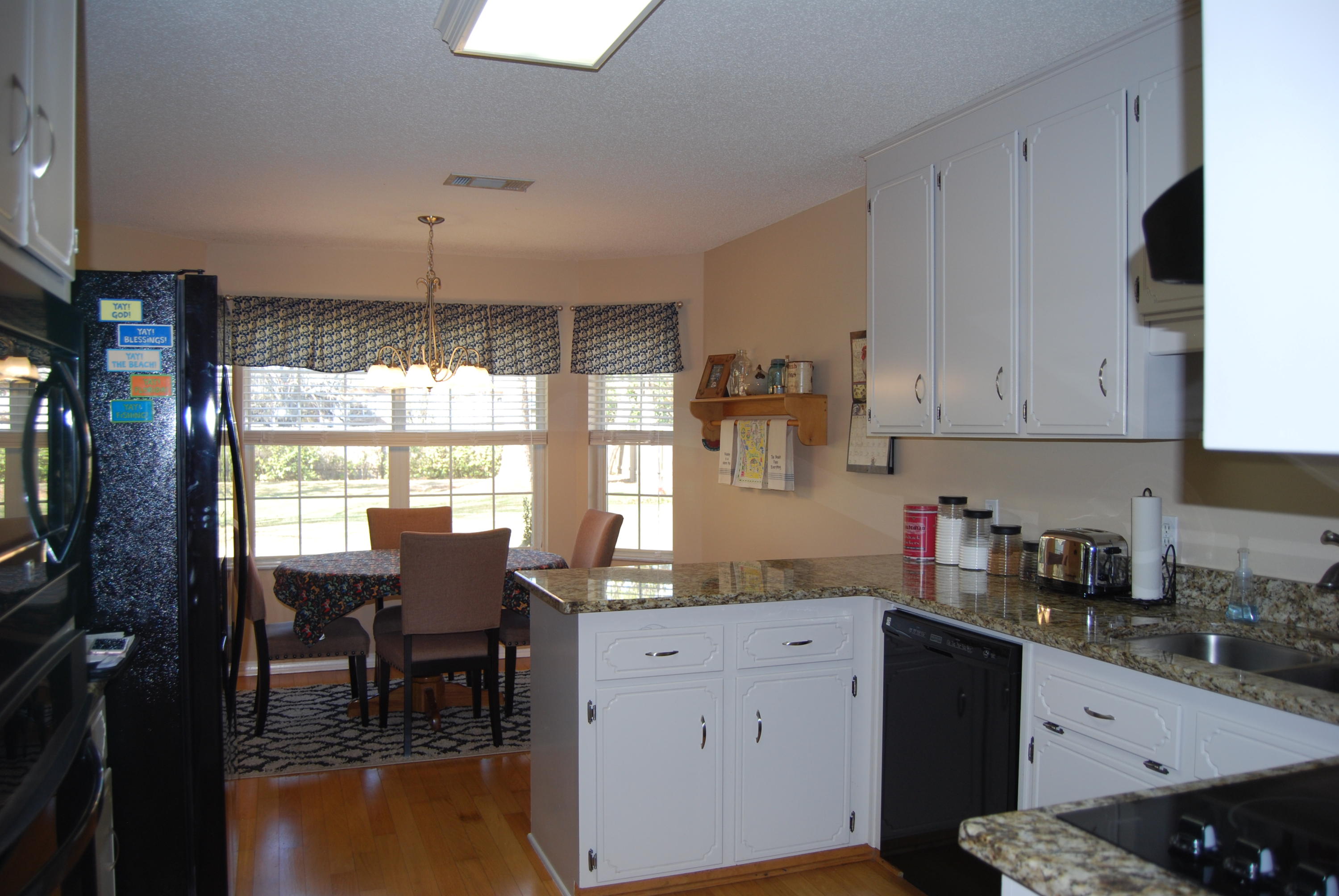 4455 Kingslynn Road Niceville, FL 32578 - Photo 9 of 36 a kitchen with granite countertop white cabinets and black appliances