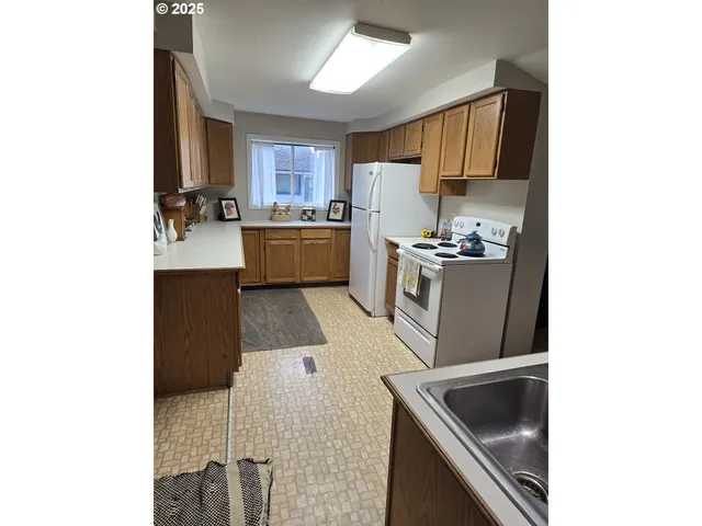 a kitchen with stainless steel appliances granite countertop a sink and a stove